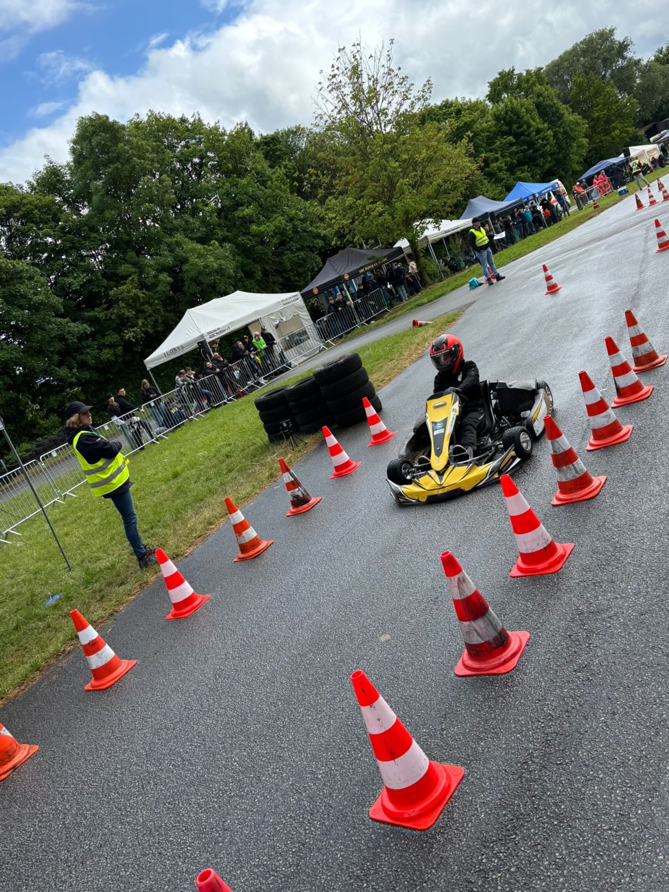Junger Fahrer im gelben Kart auf dem Slalom-Parcours