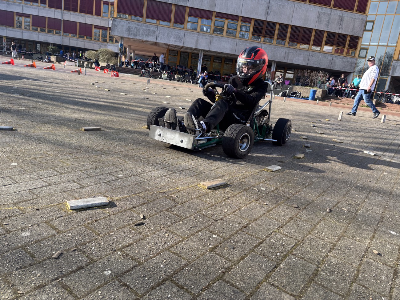 Fahrer steuert ein Kart durch die Pylonen